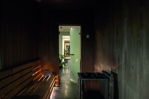 A narrow hallway with wooden walls and a bench. A door leads to a room with a plant and a chair. - Elite Plaza Hotel Malmö (Malmö)