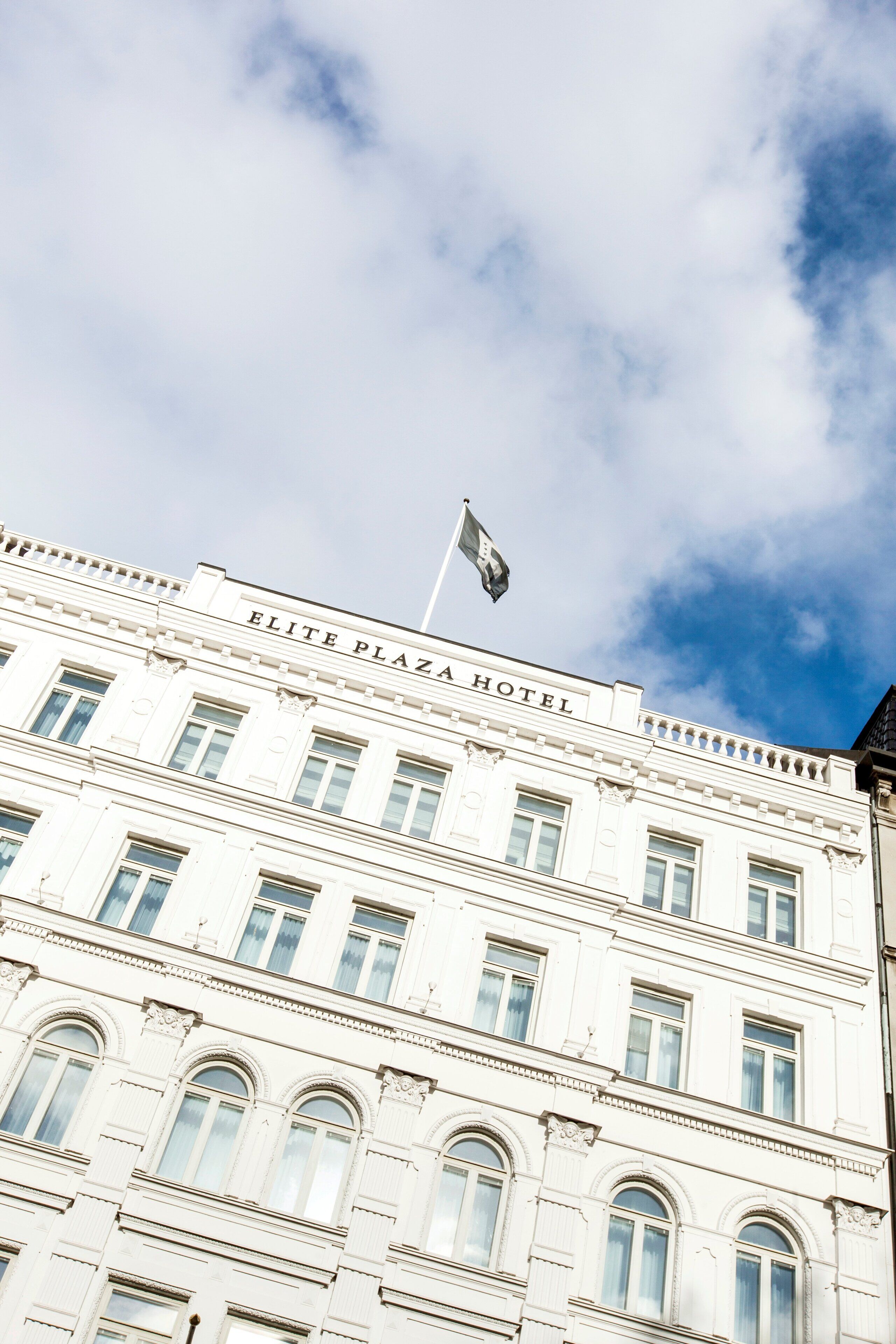 En byggnad med skylten ”ELITE PLAZA HOTEL” på fasaden.