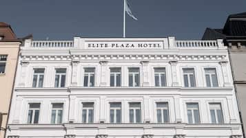 A white building with the sign "ELITE PLAZA HOTEL" at the top.