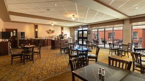 A spacious dining area with multiple tables and chairs, a bar area with a counter, and large windows providing a view of the outside. - The Kanata Inn Fort Saskatchewan (Fort Saskatchewan)