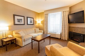 Suite, 1 cama de matrimonio grande, bañera de hidromasaje | Sala de estar | Televisión LCD de 40 pulgadas con canales por cable, una televisión