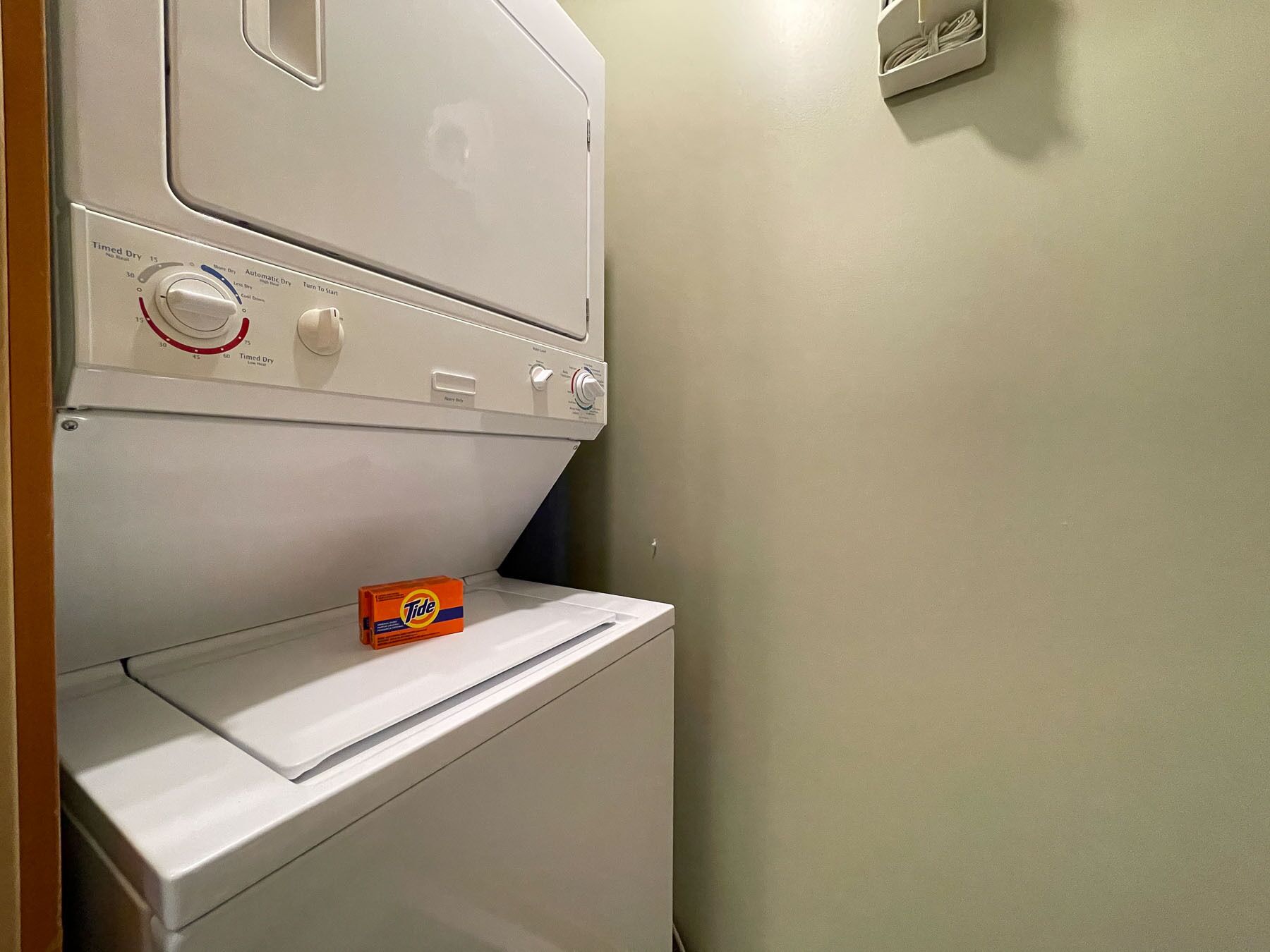 Een voorlader wasmachine met een doos Tide wasmiddel er bovenop.