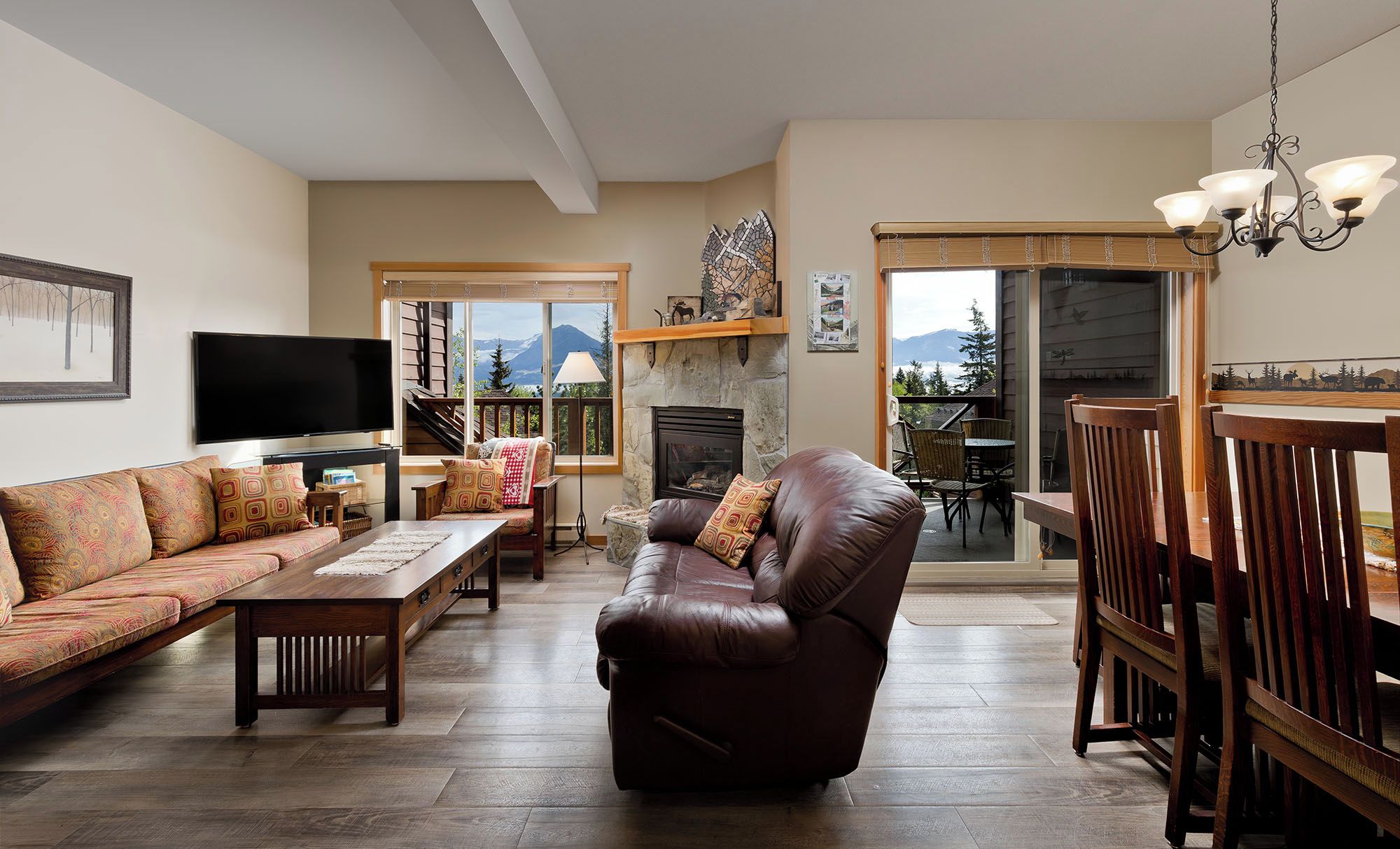 A living room with a fireplace, a sofa, a recliner, a TV, and a dining area with chairs.