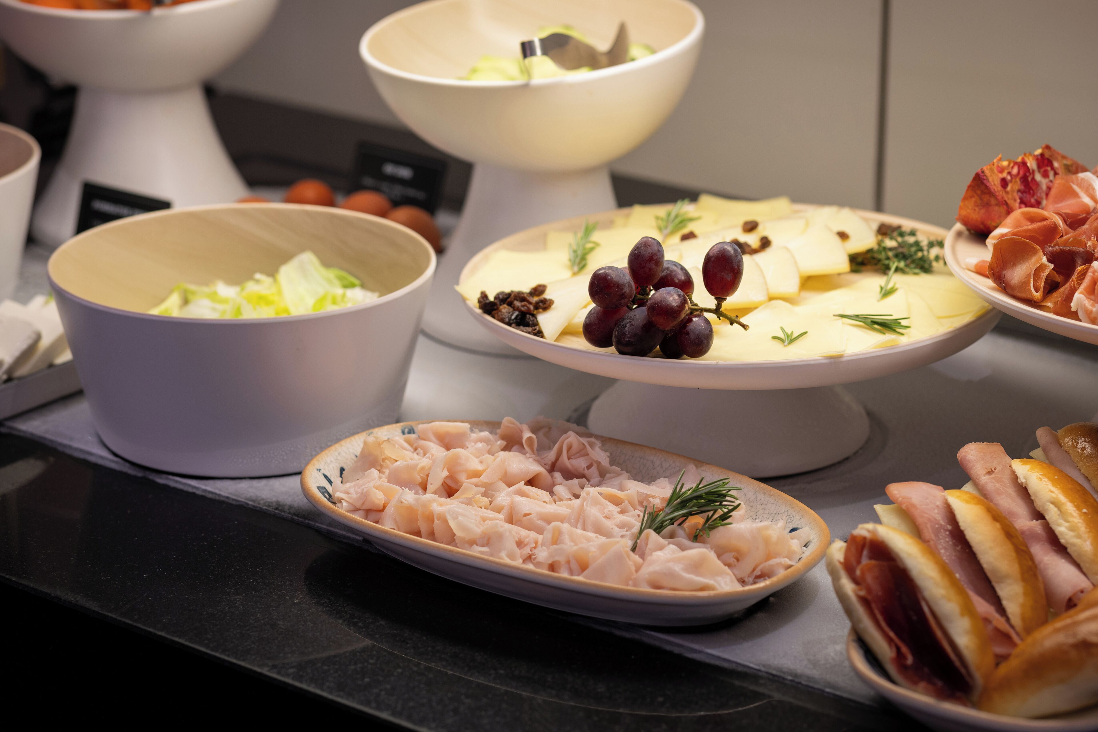 A buffet table with various dishes including pasta, cheese, and meats.