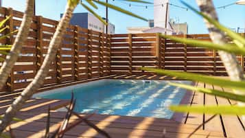 Een seizoensgebonden buitenzwembad, parasols voor strand/zwembad