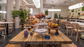 Un comedor moderno con mesas de madera, diversas opciones de comida y un diseño limpio y contemporáneo.