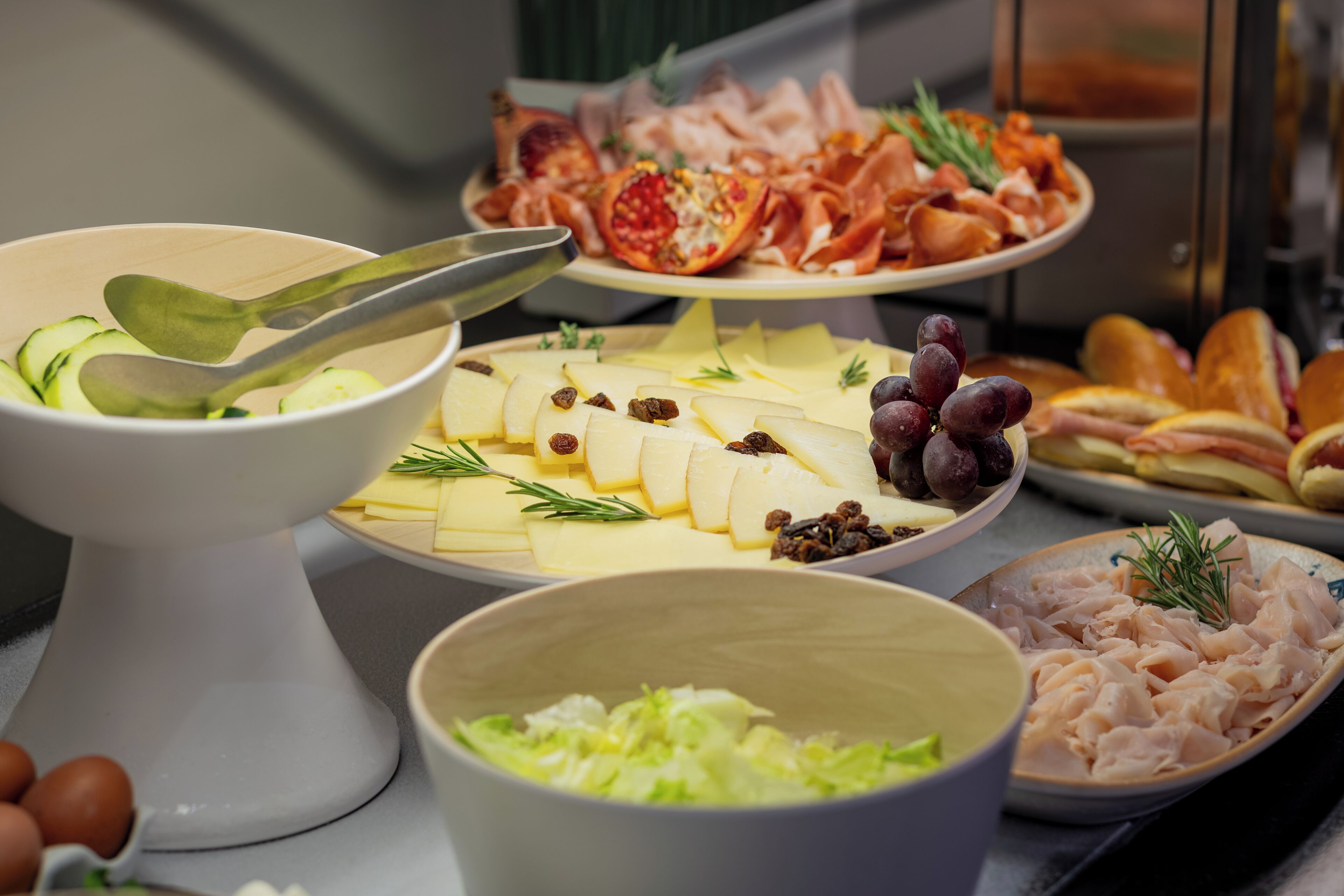 Un bufé con diversas opciones de comida, incluyendo queso, carnes y frutas.