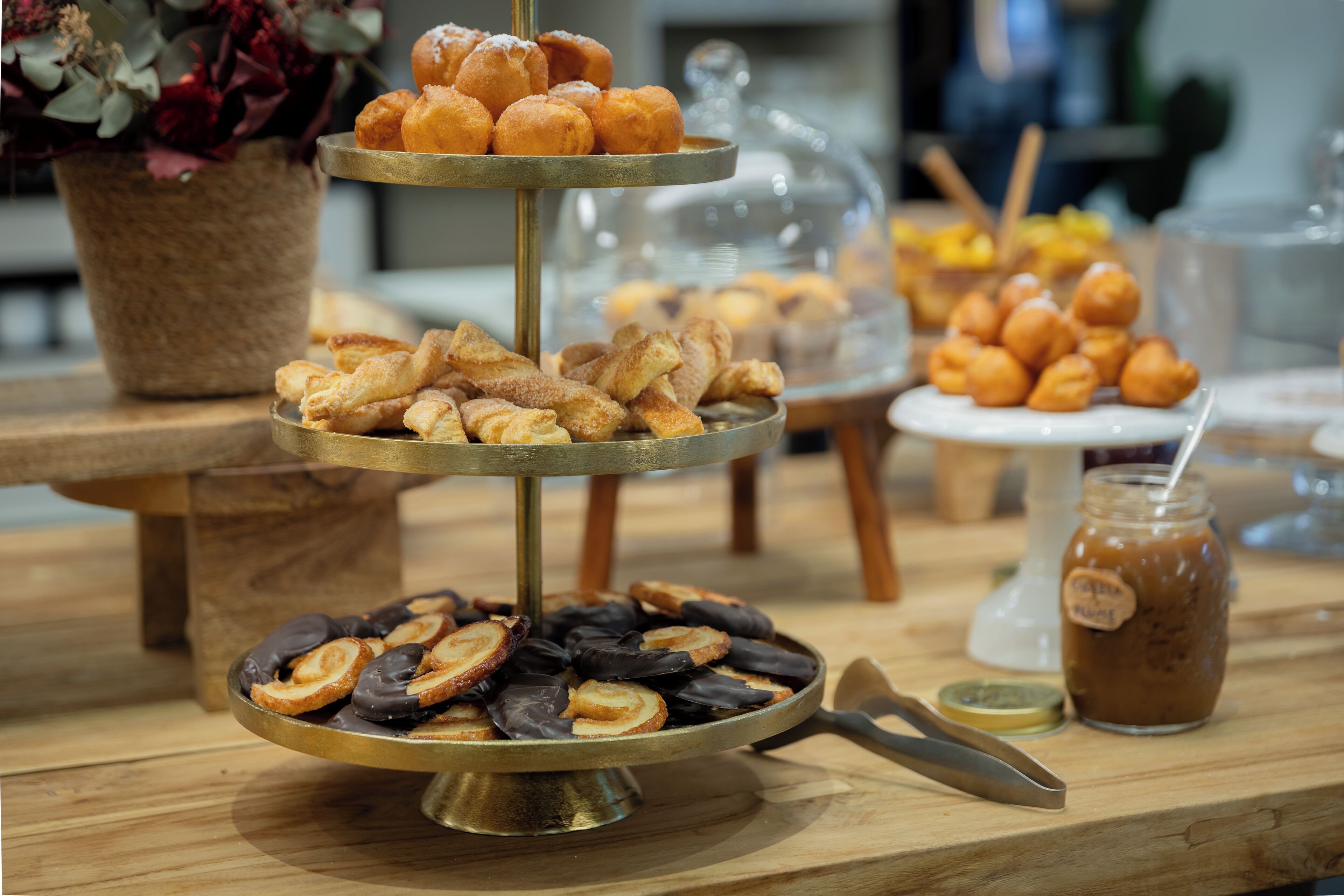 A buffet table with various pastries and a jar of iced coffee.