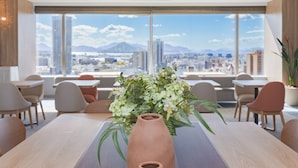 A modern conference room with a large table, chairs, and a vase of flowers. - Mitsui Garden Hotel Hiroshima (Hiroshima)