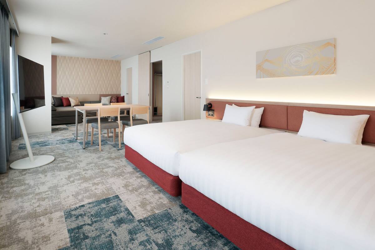 Una habitación de hotel con una cama grande, un escritorio, un sofá y un televisor.