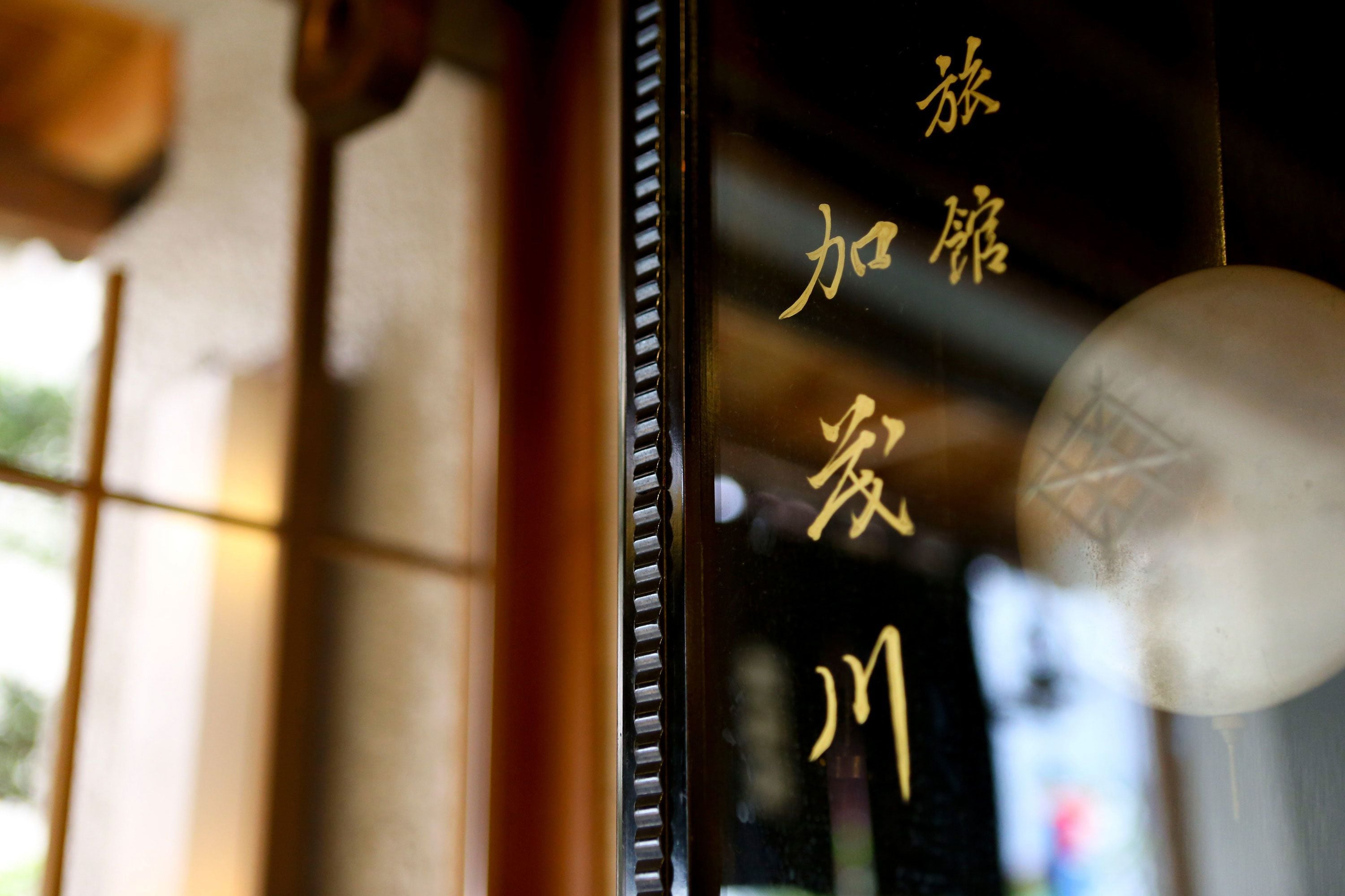 Un gros plan d’une fenêtre ornée de caractères chinois et d’un élément décoratif.