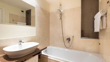 Une salle de bain moderne avec une baignoire sur pieds, un lavabo et une douche.