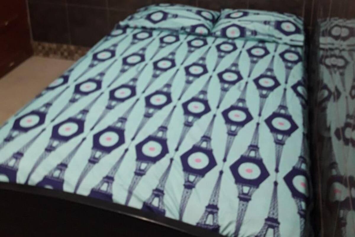 Un letto con una coperta a letto decorata da un motivo ripetuto.