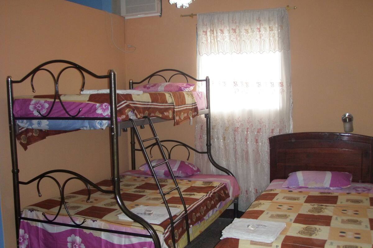Una camera del dormitorio con letti a castello, una scrivania in legno e una finestra con tenda.