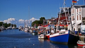 A harbor with boats docked, including a prominent 'JASMUND' boat. - Gut Gremmelin (Lalendorf)