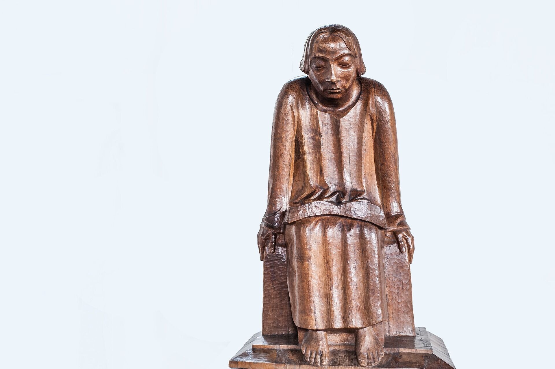 A wooden sculpture of a seated figure.