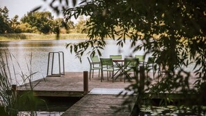 A wooden dock extending into a calm lake, surrounded by greenery and trees. - Gut Gremmelin (Lalendorf)