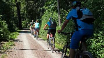 A group of cyclists on a gravel path surrounded by dense greenery.
