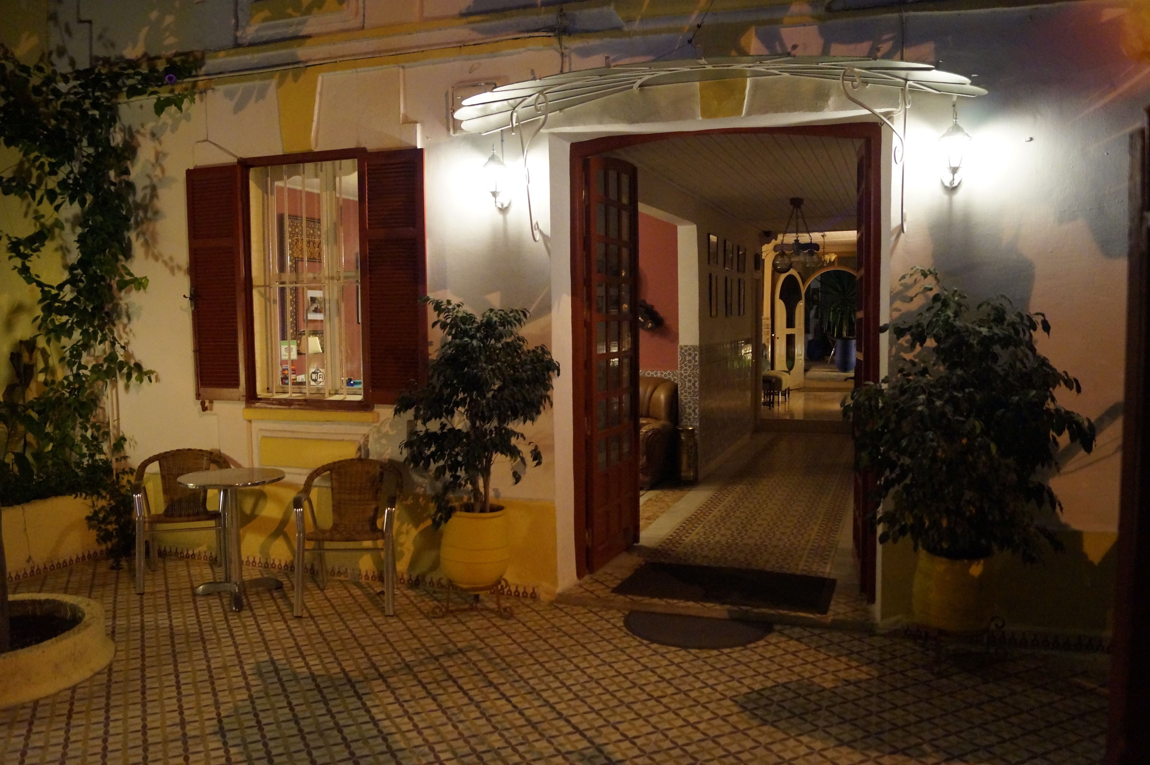 A cozy outdoor seating area with a tiled floor and potted plants.