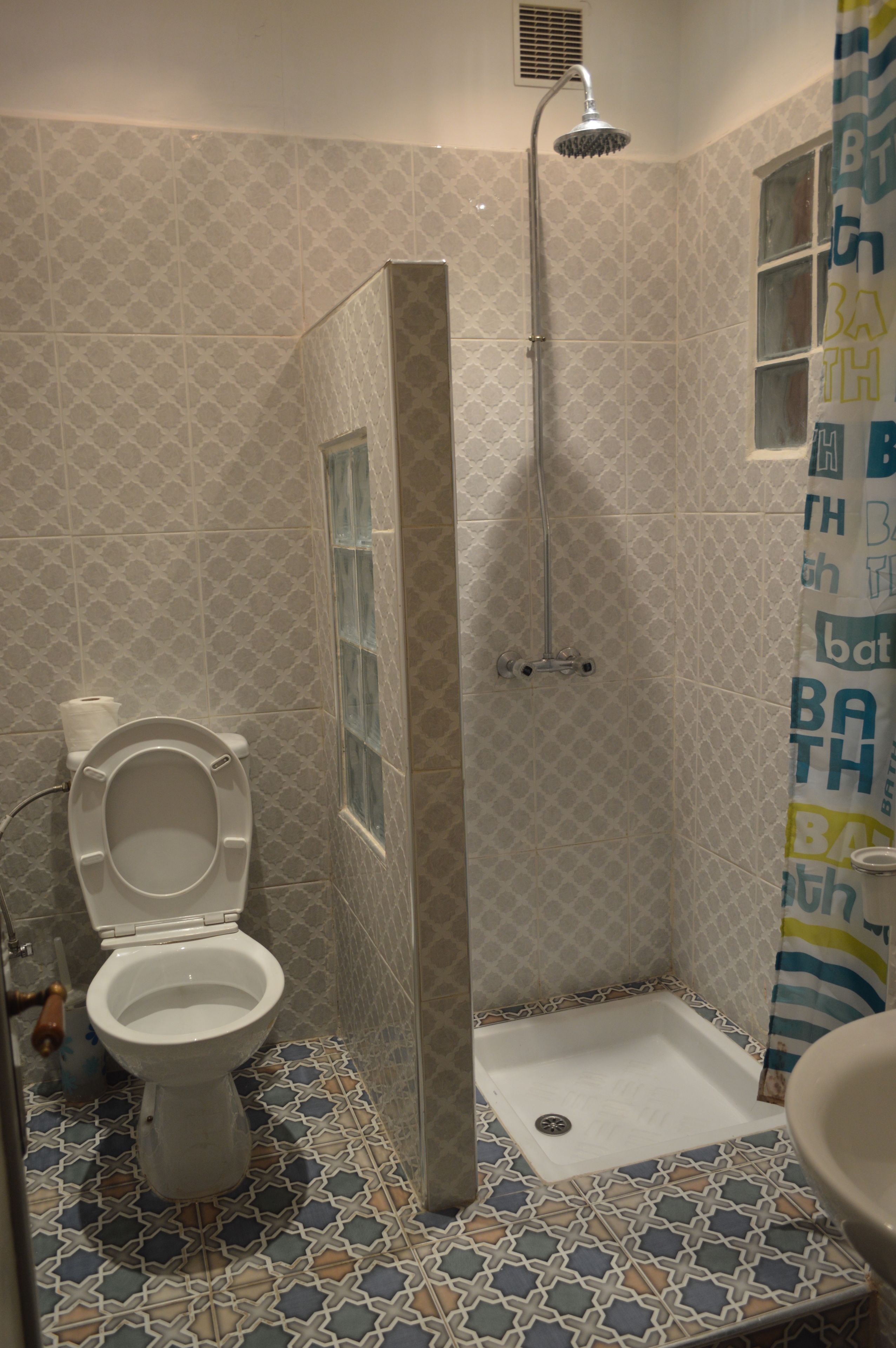 Une salle de bain avec des toilettes, une douche et un lavabo.