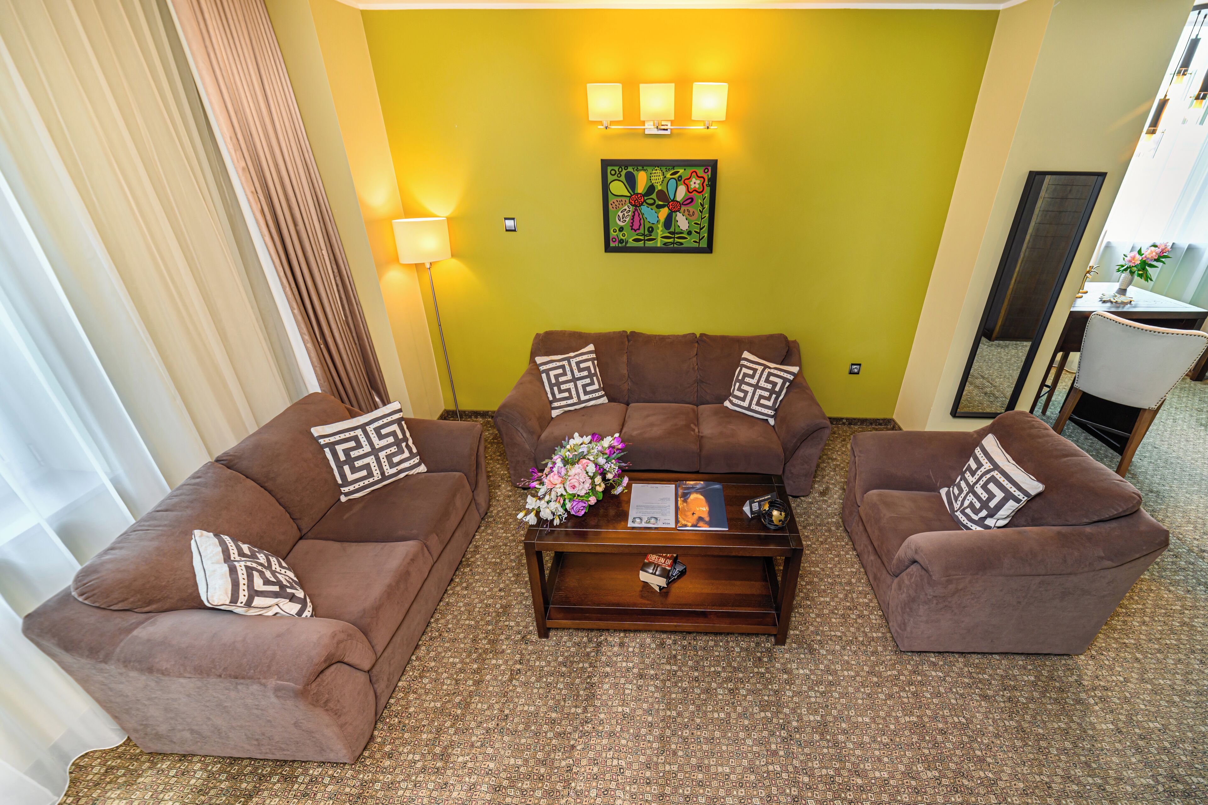 Una sala de estar con dos sofás marrones, una mesa de centro y un arreglo floral.