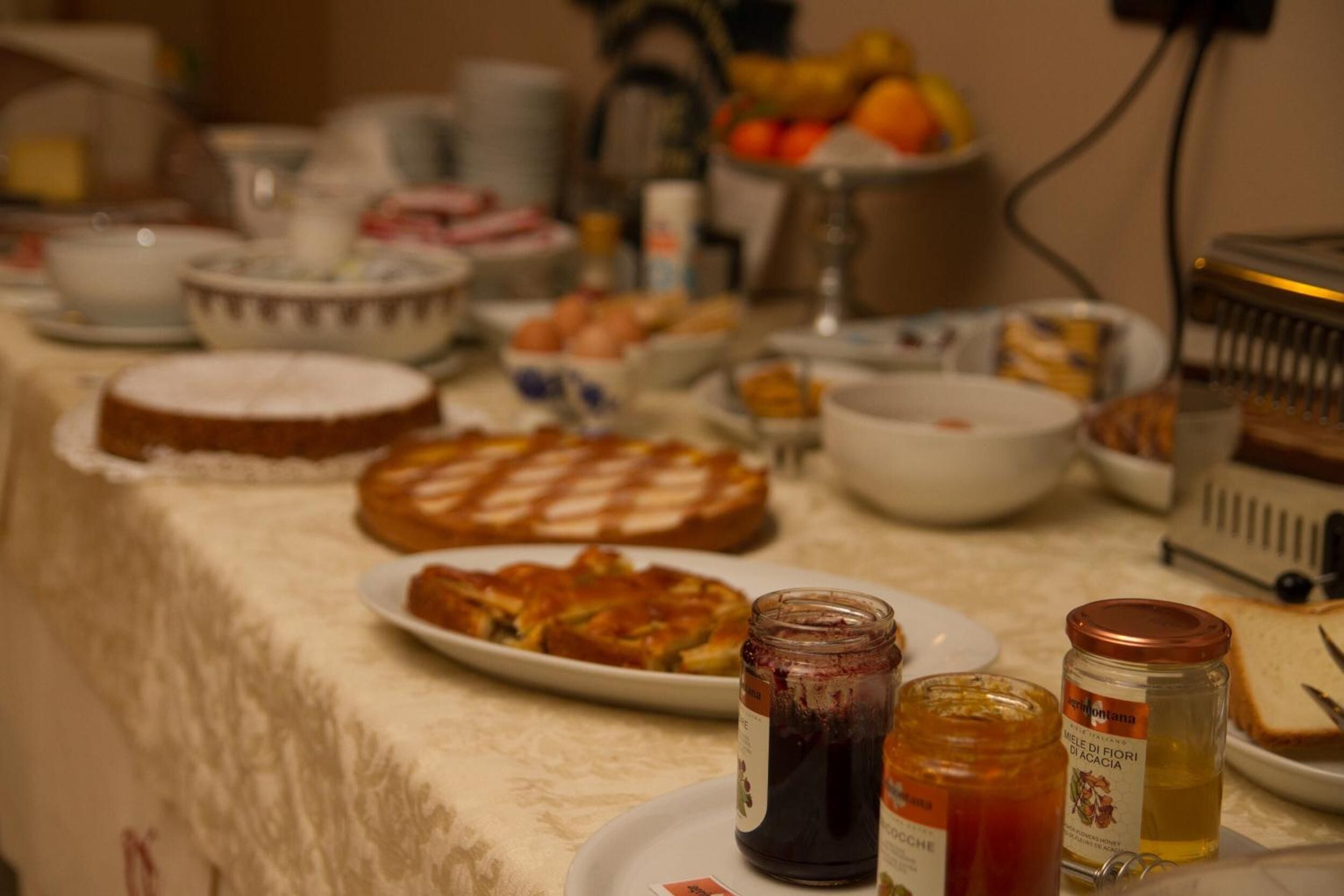 Une table de buffet proposant divers plats, notamment un gâteau, une tarte et plusieurs pots de condiments.