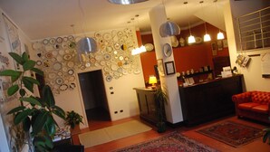 A living room with a wall of plates, a red sofa, a coffee table, and a rug.