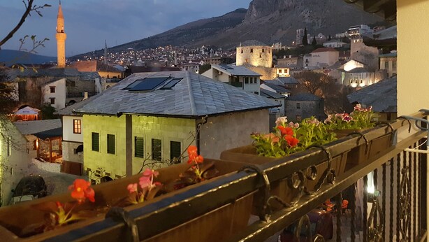 A balcony with a view of a town, including buildings and a mountain in the background. - Villa Cardak (Mostar)