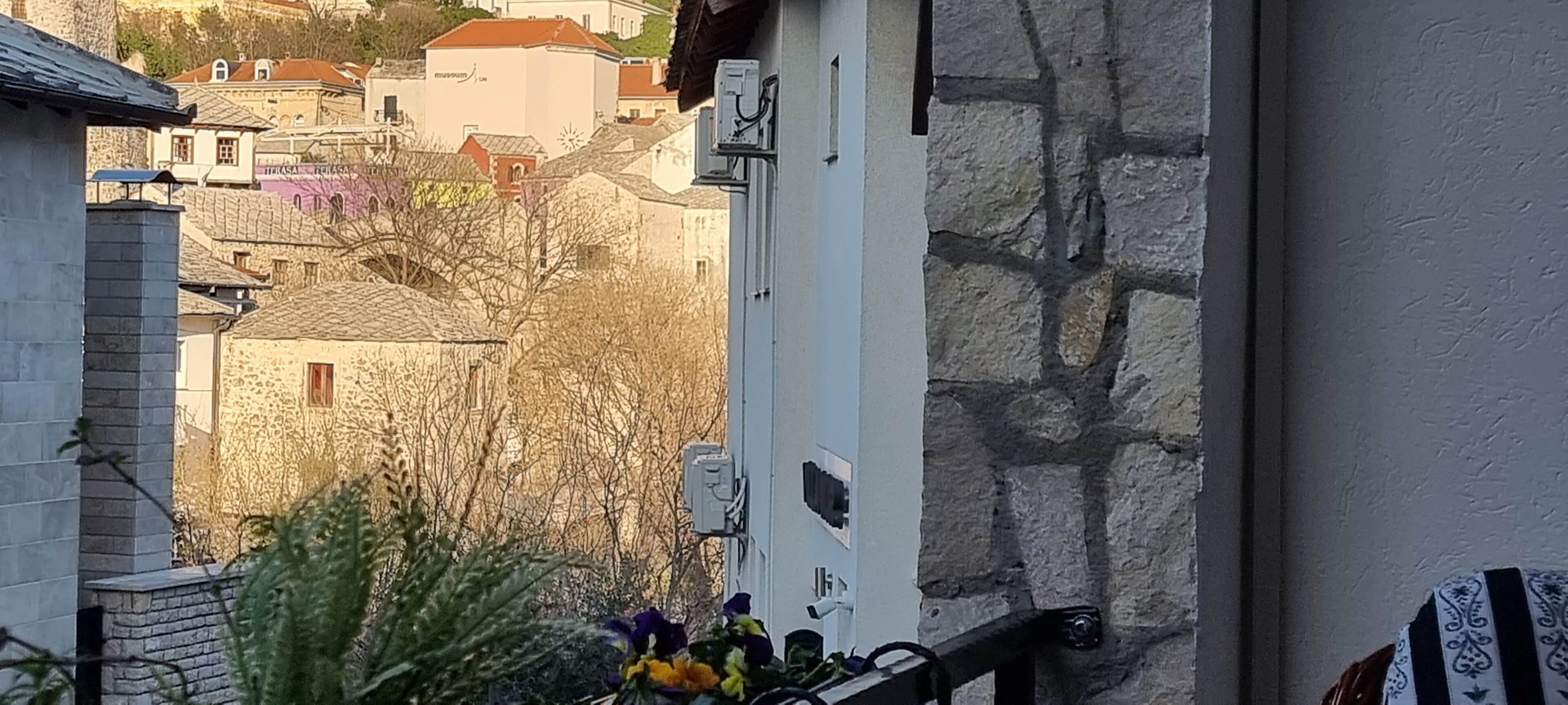 A stone wall with a utility box and a metal railing.