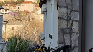 Un mur de pierres avec un coffret de raccordement et une rambarde en métal.