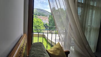 Un balcón con vista a un pueblo y una colina.