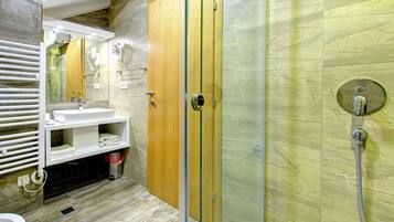 A modern bathroom with a glass-enclosed shower, a white sink, and a wooden vanity.