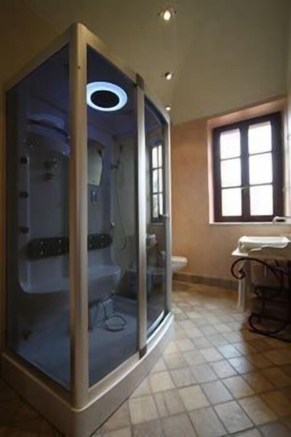A bathroom with a glass-enclosed shower, a toilet, and a sink. - Relais I Castagnoni (Rosignano Monferrato)