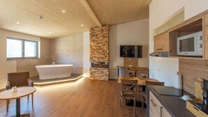 Una cocina moderna con una pared de acento de piedra, armarios de madera y un microondas empotrado.