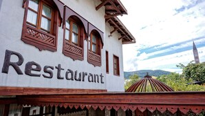 Un edificio con un cartel que dice "Restaurant" y una estructura de madera tradicional en primer plano.