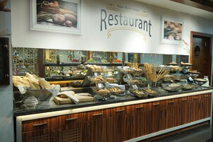 En buffet med forskellige retter og brød i kurve.