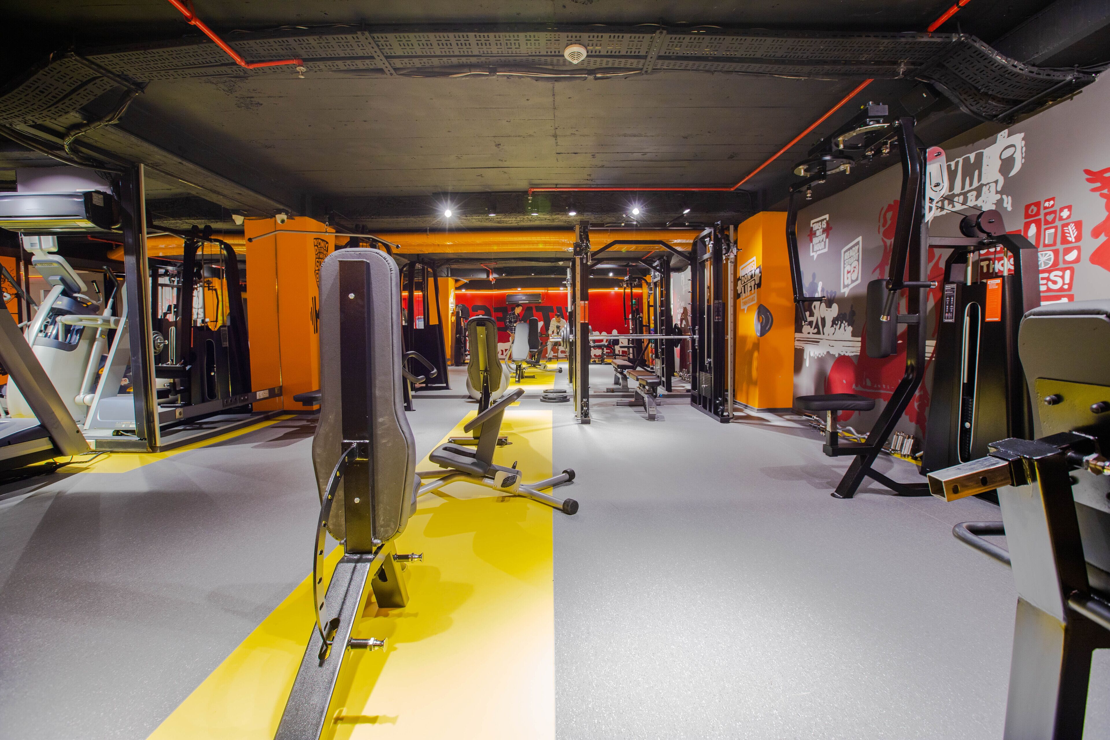A gym with various exercise equipment, including a treadmill, stationary bike, and weight machines.