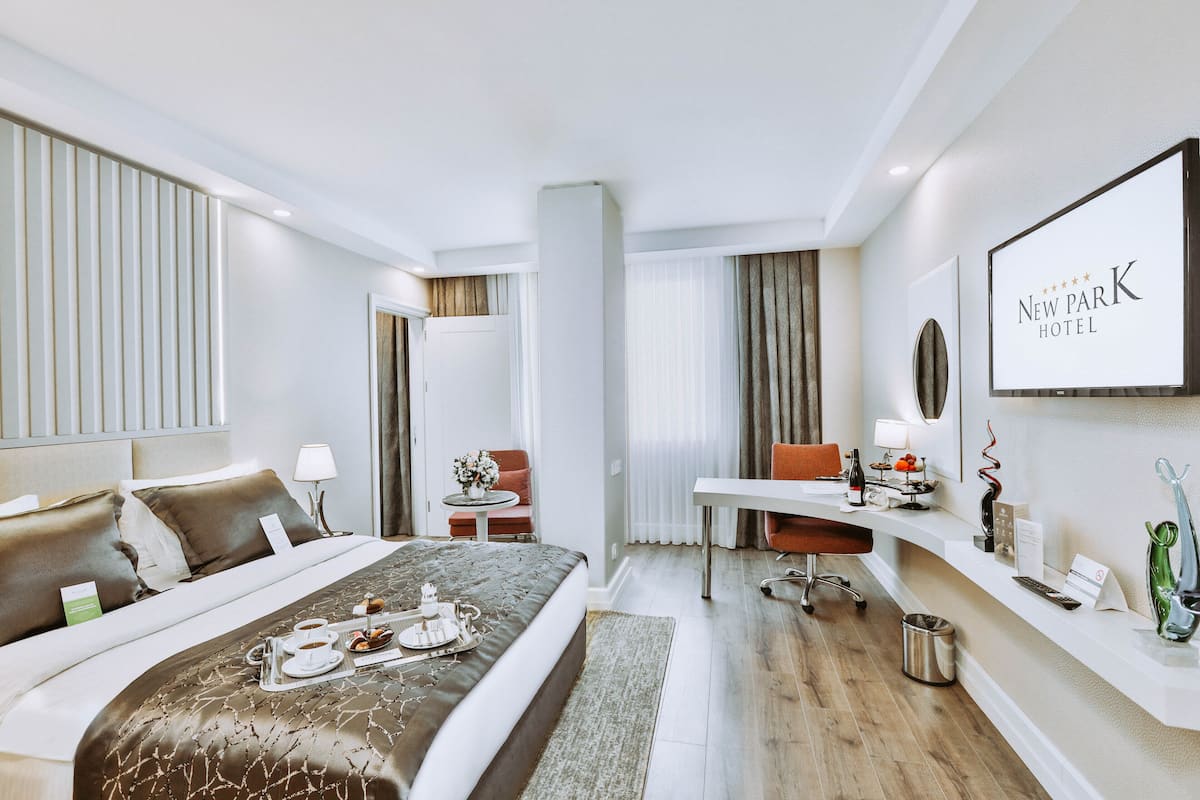 Ein modernes Hotelzimmer mit einem großen Bett, einem Schreibtisch und einer Sitzecke.