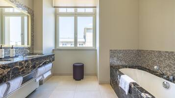 Ein modernes Badezimmer mit einem großen Spiegel, einer Badewanne und einem Waschtisch mit Marmorplatte.