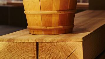 Un balde de madera con asa y una cuchara de madera descansando sobre una superficie de madera.