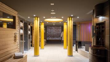 Un lobby moderno de hotel con una zona de estar central, una pared de ladrillo y un mostrador de recepción.