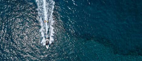 Vista aérea de um barco em um mar azul e límpido.