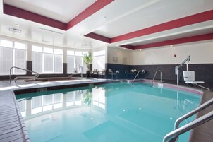 Una piscina techada, sillones reclinables de piscina