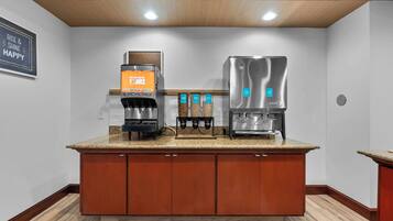 A modern kitchen with a coffee machine, a water dispenser, and a built-in oven.