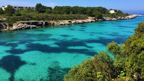 Un paysage côtier caractérisé par une eau turquoise cristalline, une côte rocheuse et une végétation luxuriante.