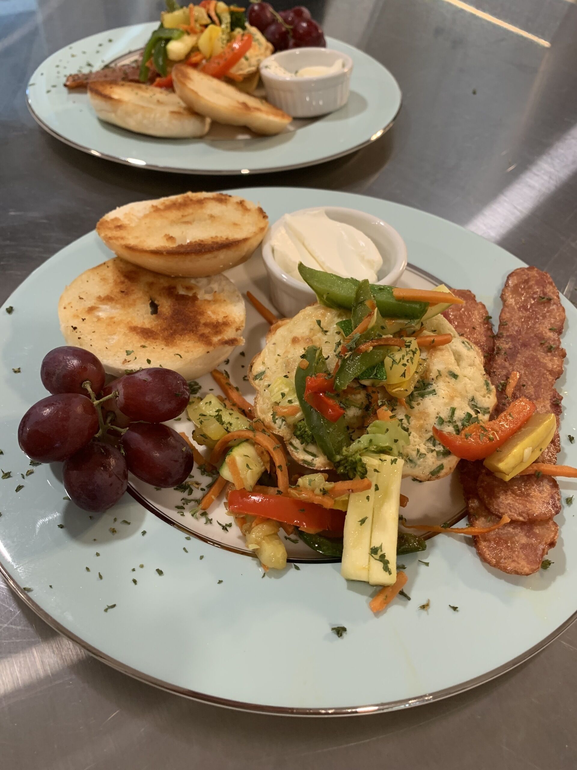 A plate with grilled meat, vegetables, and a side of sauce.