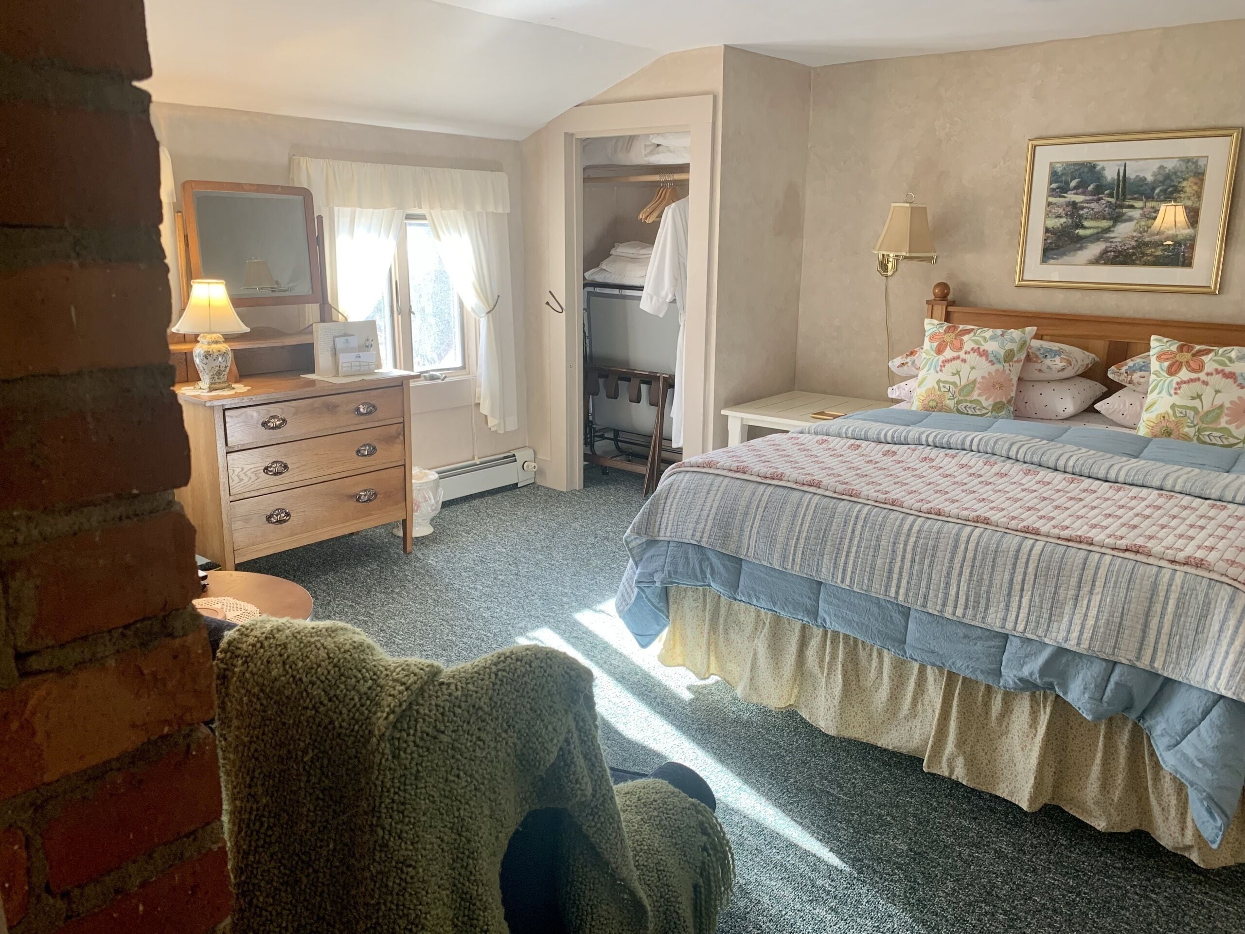 Un dormitorio con cama, cómoda, espejo y armario.