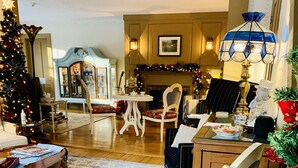 Ein gemütliches Wohnzimmer mit Weihnachtsbaum, Kamin und Essbereich mit Tisch und Stühlen.