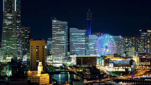 A nighttime cityscape with illuminated skyscrapers and a prominent Ferris wheel. - Hotel Plumm (Yokohama)
