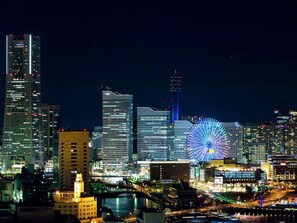 A nighttime cityscape with illuminated skyscrapers and a prominent Ferris wheel. - Hotel Plumm (Yokohama)
